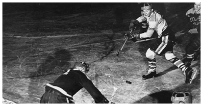 A hockey player is laying on the ground and another player is standing up.