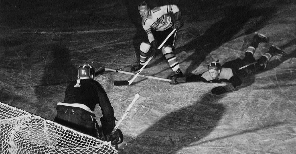 A hockey player is on the ice with his stick.