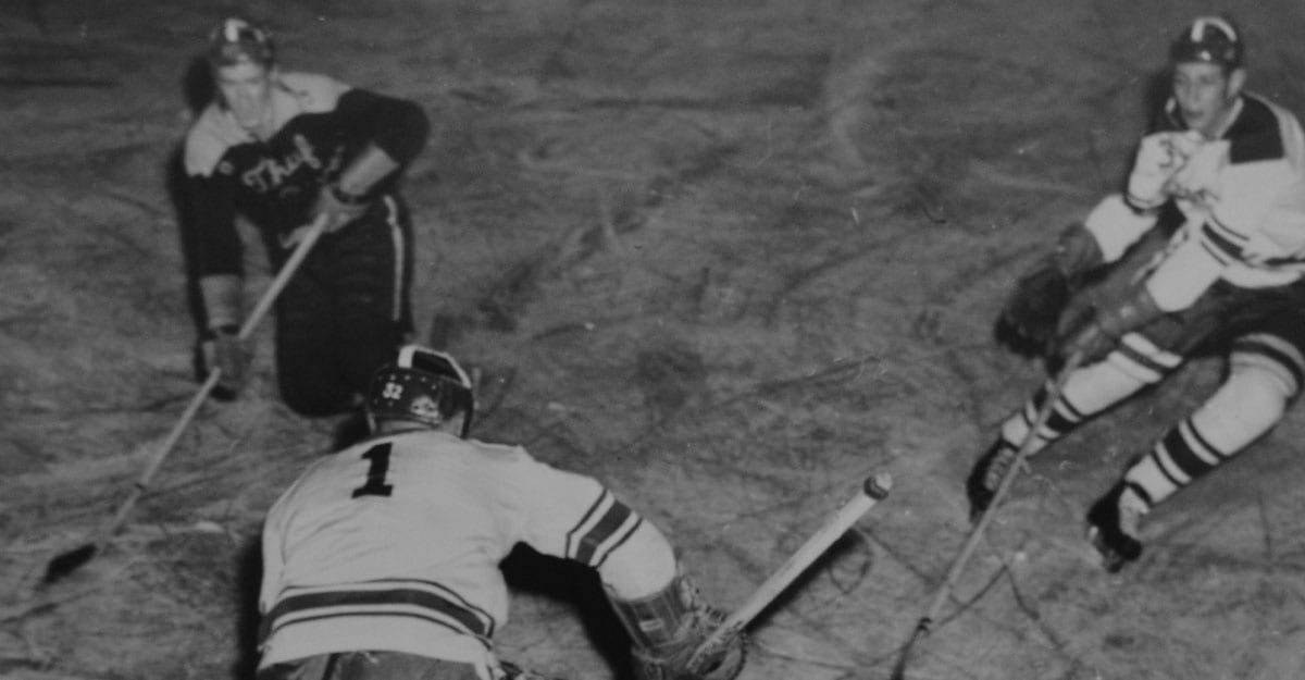 A hockey player laying on the ground with his head down.