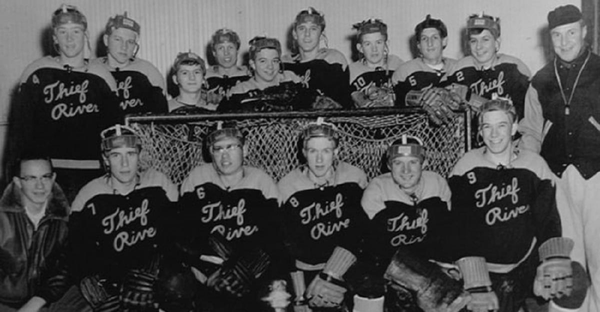 A group of men in hockey uniforms sitting on top of a bench.