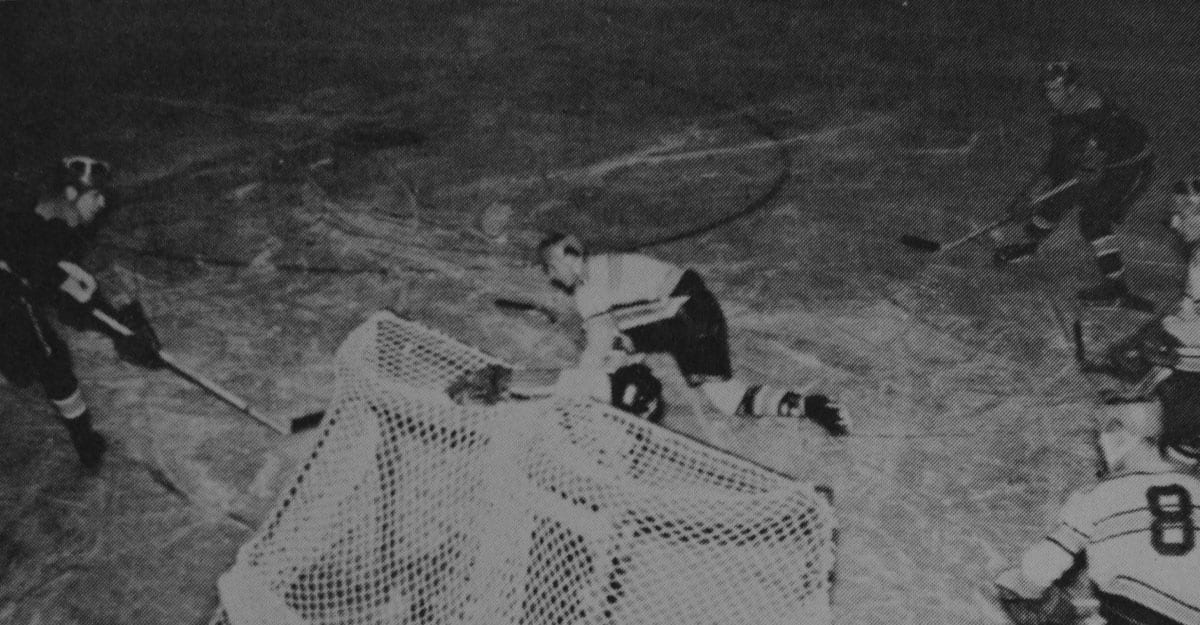 A man is laying on the ground in front of a net.