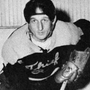 A man in a hockey uniform holding a glove.