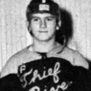 A young man in a hockey uniform is posing for the camera.